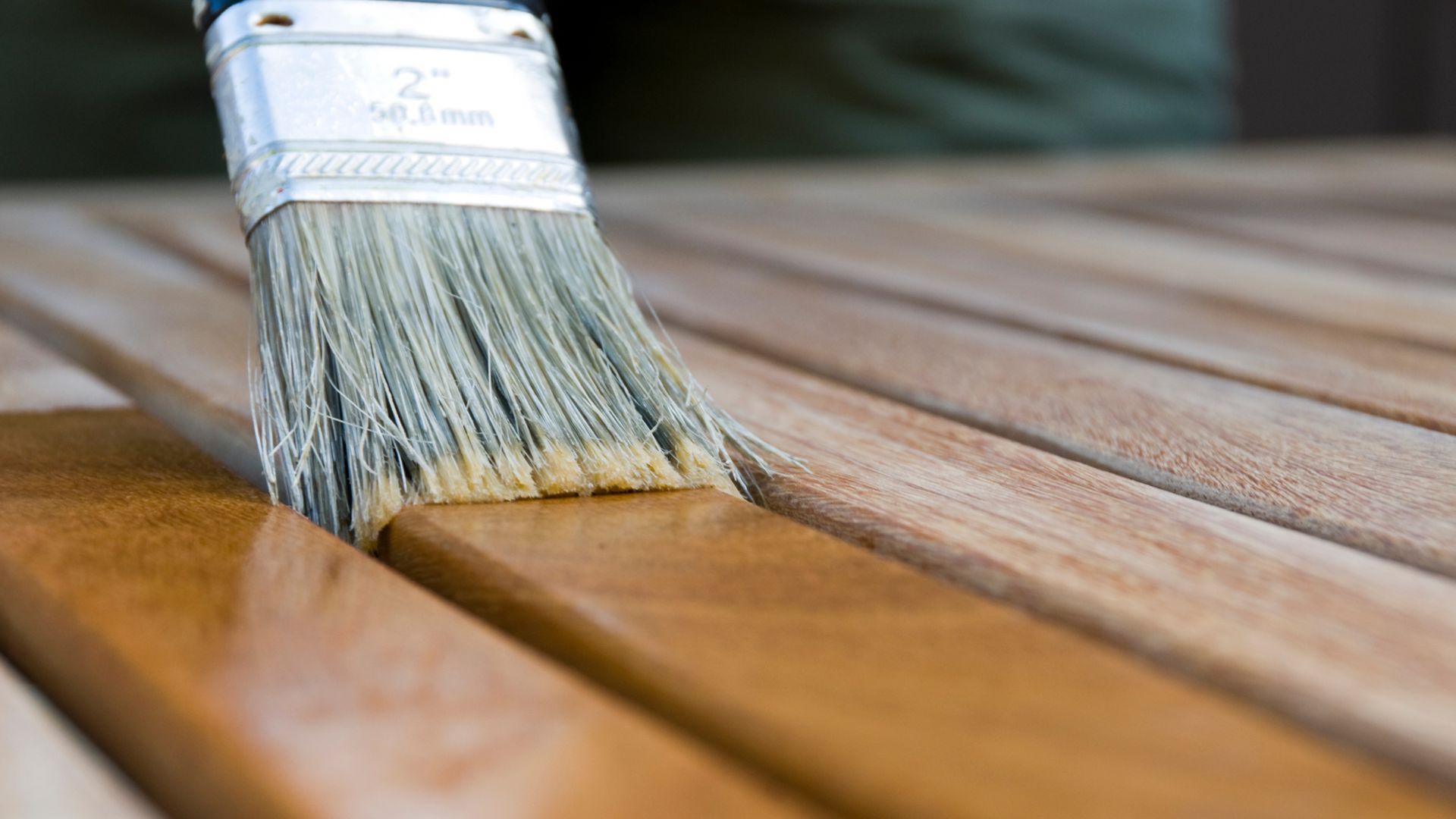 A close up of a paint brush on a wooden table