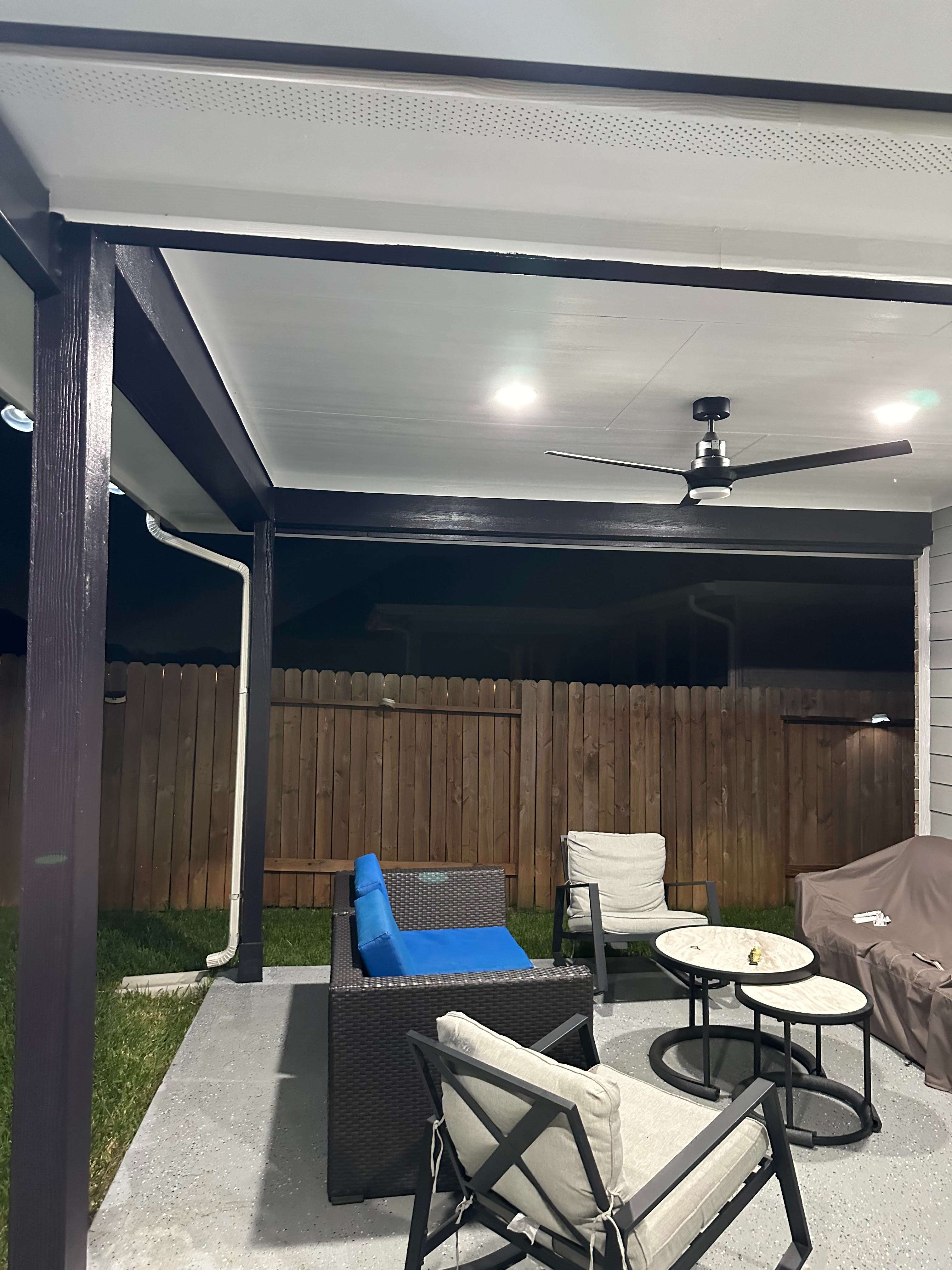 A covered patio with chairs and a table